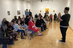 Photograph showing students watching the artist lecture.