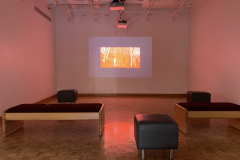 Installation shot of gallery showing video projected on rear wall.