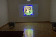 Installation shot of gallery showing video projected on rear wall.